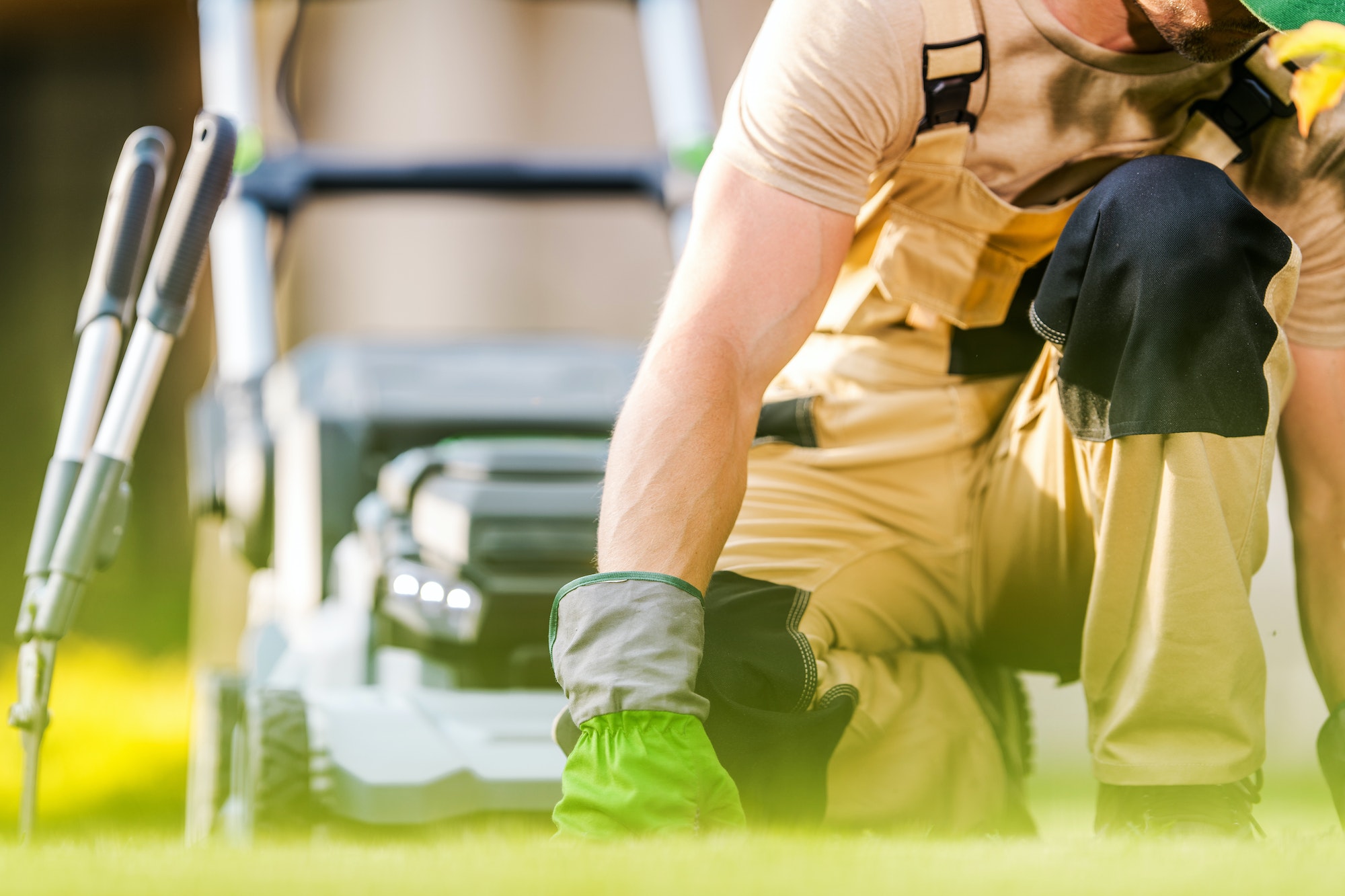 Caucasian Landscaper Inspecting Backyard Lawn Grass