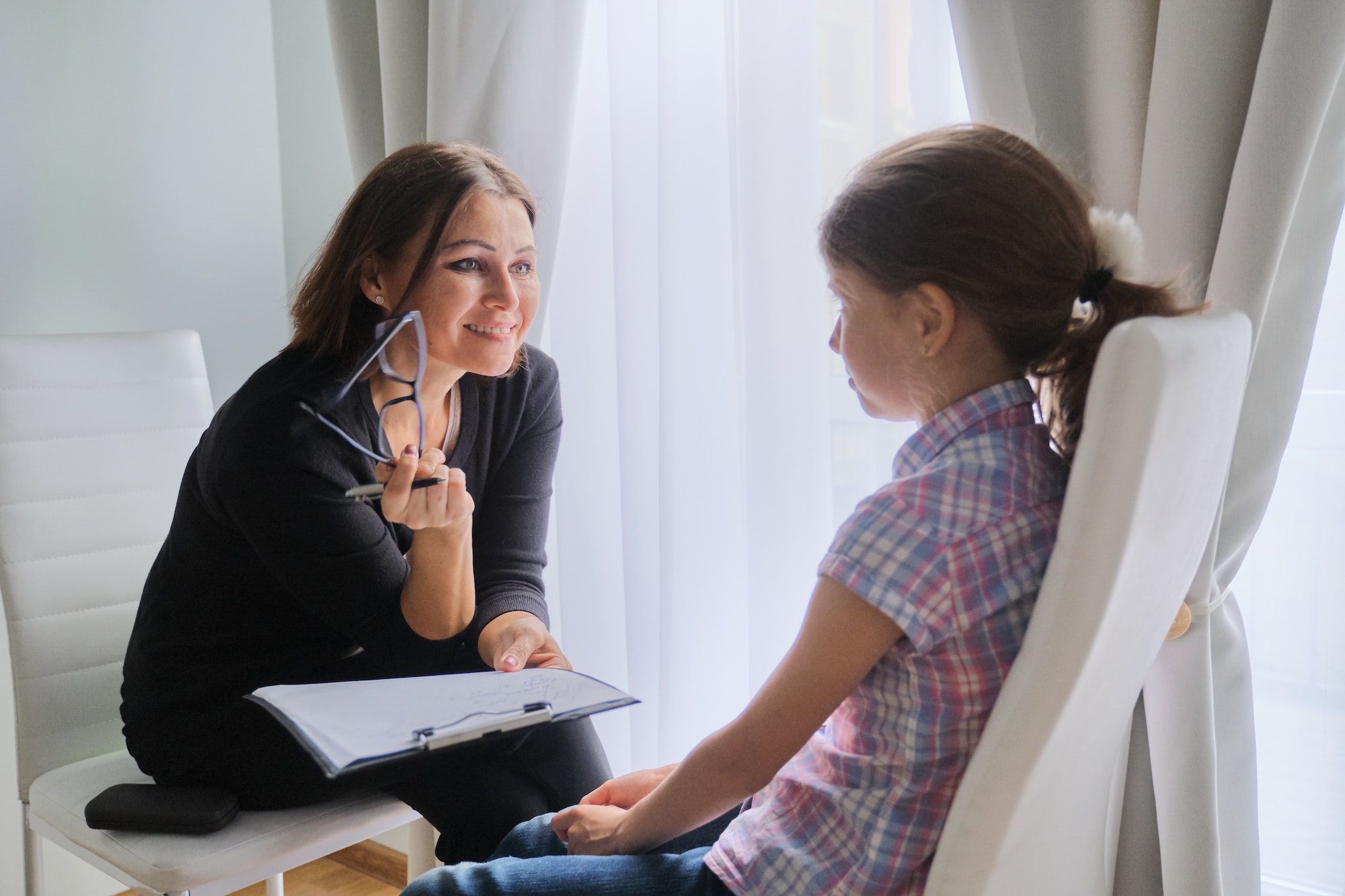 Woman social worker talking to girl. Child psychology, mental health