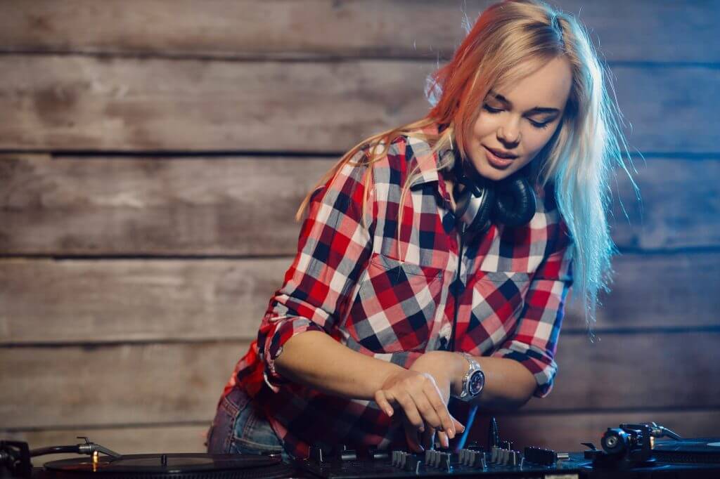 Cute dj woman having fun playing music at club party